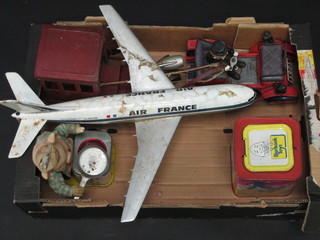 A red painted pressed metal model of a crane, an E F Phelps Air France model aircraft, a battery operated tin plate model of a  vintage car, a Tom and Gerry tin plate musical jack in the box  and a battery operated tin plate Piggy Cook