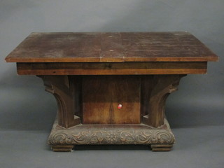 An Art Deco Continental walnut drawleaf dining table, raised on  a carved shaped base 53", top missing,