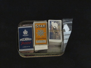 A collection of cigarette cards in a metal box