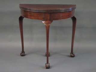 A Georgian style mahogany demi-lune card table, raised on cabriole claw and ball supports 30"