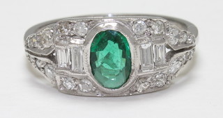 An 18ct white gold dress ring set an oval cut emerald surrounded  by diamonds, approx 0.75ct/0.55ct