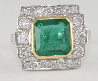 An 18ct white gold dress ring set a square cut emerald  surrounded by diamonds approx 2.85/0.75ct