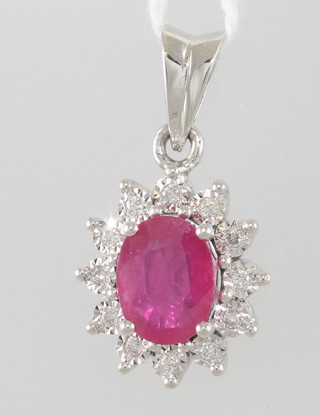 An 18ct white gold pendant set an oval cut ruby surrounded by diamonds