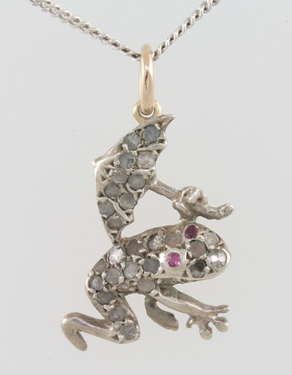 A gold pendant in the form of a frog set diamonds and rubies, hung on a fine gold chain