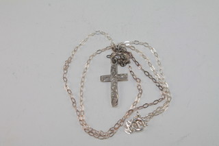 A silver cross hung on a fine chain