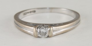 An 18ct white gold dress ring set a small diamond
