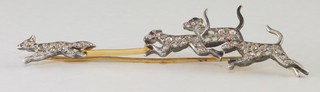 A gold bar brooch in the form of a fox and 3 hounds with ruby  set eyes