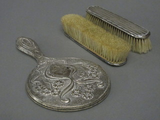 A hand mirror with embossed silver back and 2 silver backed  clothes brushes