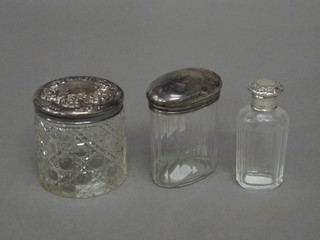 An oval cut glass pin jar with silver lid 3", a cylindrical hobnail cut dressing table jar with silver lid 3" and a perfume bottle with  silver lid 3"