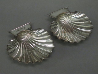 A pair of silver plated scallop shaped butter dishes