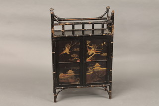 An Oriental bamboo and lacquered cabinet the shelved interior enclosed by a panelled door 19"