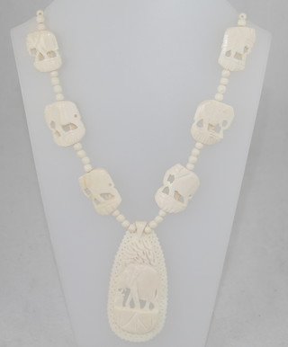 A set of carved ivory beads hung a pierced carved ivory pendant decorated an elephant