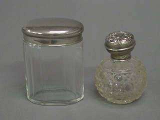 An oval panel cut pin jar with silver lid and a globular cut glass scent bottle with embossed silver lid