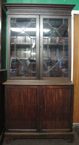 A Georgian mahogany display cabinet on cabinet with associated top with moulded and dentil cornice, the shelved interior  enclosed by astragal glazed doors, the base fitted a cupboard  enclosed by panelled doors, raised on bracket feet 41"
