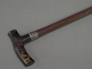 A walking cane with silver band and horn handle