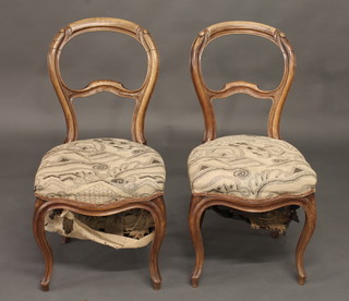 A pair of bleached mahogany balloon back dining chairs with shaped mid rails, the seats of serpentine outline and raised on  cabriole supports