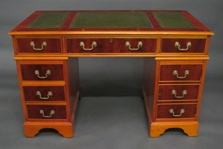 A Georgian style yew kneehole pedestal desk inset a green  leather writing surface above 1 long and 8 short drawers 48"