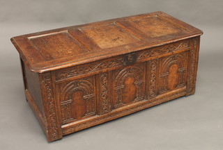An 18th Century carved oak coffer of panelled construction fitted  a candle box 48"  ILLUSTRATED