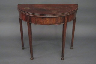 A Georgian mahogany demi-lune card table, raised on square tapering supports ending in spade feet 34"