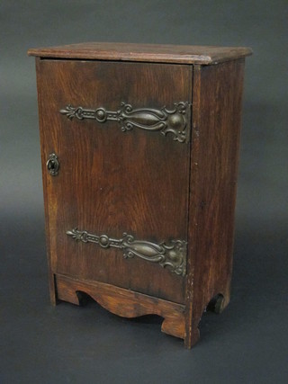 An Art Nouveau oak table top cabinet, the interior fitted shelves enclosed by a panelled door with embossed hinges 12"