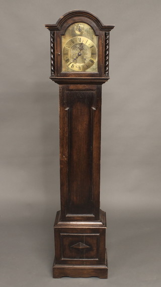 A 1930's striking Granddaughter clock with 7 1/2" arched brass dial contained in an oak case, with sliding hood 61 1/2"