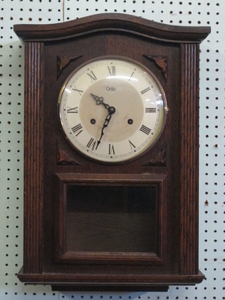 A Continental striking wall clock with silvered dial and Roman numerals, the dial marked ODO and contained in a carved oak  case