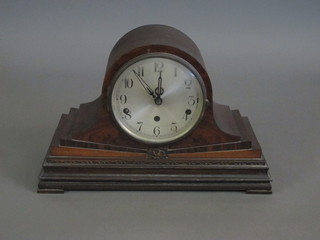 An Art Deco 8 day chiming mantel clock with silvered dial and Arabic numerals contained in a walnut admiral's hat shaped case