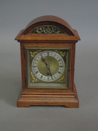 An Edwardian Continental 8 day bracket clock with 6" square  brass dial and silvered chapter ring, contained in an oak arch  shaped case