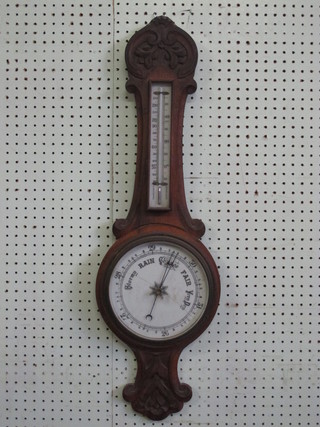 An aneroid barometer and thermometer with porcelain dial contained in a carved oak case