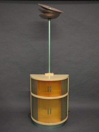 An Art Deco cream painted revolving cabinet incorporating a standard lamp