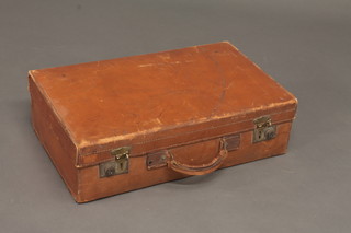 A brown leather suitcase with brass fittings