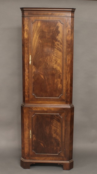 A Georgian style mahogany double corner cabinet with moulded cornice, both sections fitted shelves enclosed by panelled doors,  raised on bracket feet 24"