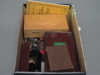 A box containing a collection of draft sets, lenses other curios etc