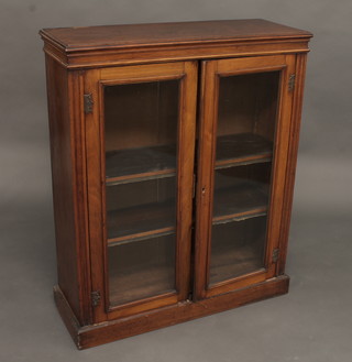A Victorian mahogany cabinet, the shelved interior enclosed by glazed panelled doors, raised on a platform base 33 1/2"