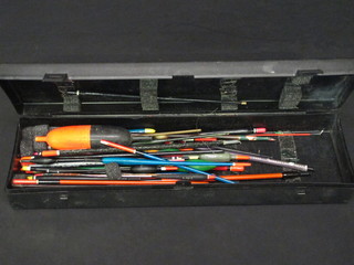 A rectangular black plastic box containing a collection of fishing floats