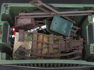 A green plastic crate containing large gauge rails