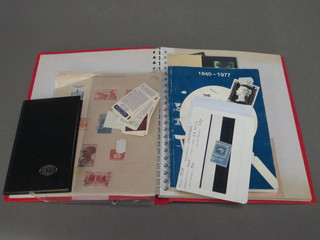 A small black stock book of stamps and a small collection of  stamps