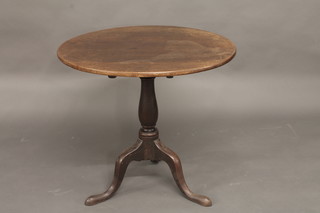 A 19th Century circular oak snap top tea table, raised on a pillar  and tripod base 30"