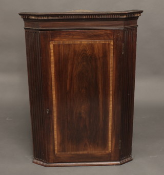 A Georgian mahogany corner cabinet with moulded cornice, the interior fitted shelves enclosed by panelled doors and with fluted  columns to the sides 29"