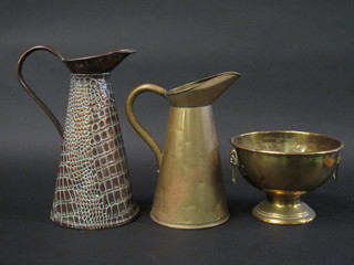 An embossed copper jug 11", a brass jug 12" and a circular brass  twin handled bowl