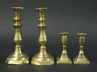 A pair of 19th Century brass candlesticks with ejectors 9" and a  squat pair of candlesticks with ejectors 5"