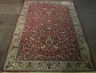 A red ground machine made Persian style carpet decorated animals amidst flowers 96" x 67"