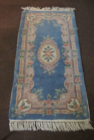 A Indian blue ground and floral patterned rug 60" x 29"