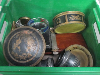 A green crate containing 2 tins and a collection of curios