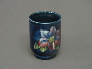 A Moorcroft blue glazed cylindrical vase decorated a pansy, the base impressed Moorcroft Made in England 3"
