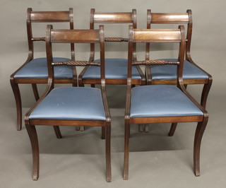 A set of 5 Regency style mahogany bar back dining chairs with  upholstered seats, raised on sabre supports