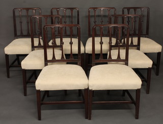 A set of 8 Georgian mahogany stick and rail back dining chairs  with upholstered seats, raised on square tapering supports with H  framed stretcher