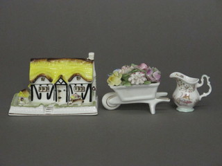 A Coalport model - Elizabethan Cottage, together with a Royal Doulton wheelbarrow of flowers 3" and a do. miniature jug 2"