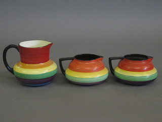 A Carltonware multi coloured striped jug 5" and a pair of Carltonware multi coloured striped jugs