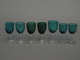 7 various green glass wine glasses with clear glass stems